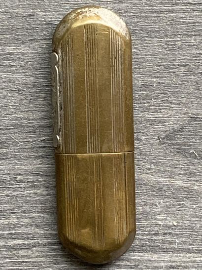 Un briquet en métal doré avec l'inscription...