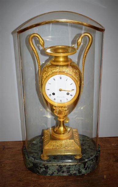 A clock in the shape of an ovoid vase in...