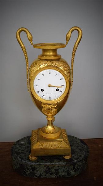 A clock in the shape of an ovoid vase in...