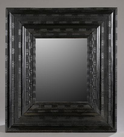 Miroir dans un grand cadre en bois noirci...