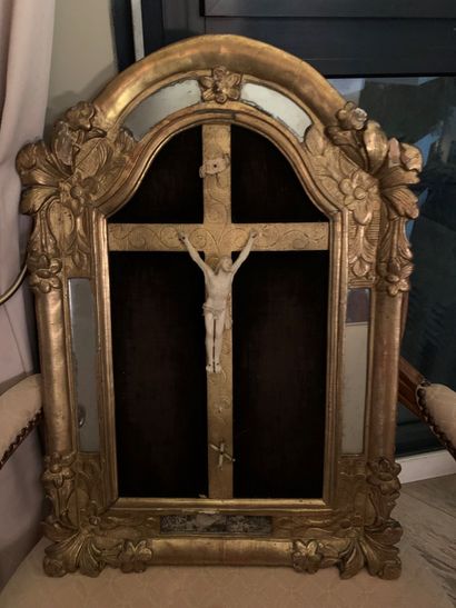 Un crucifix dans un encadrement en bois doré...