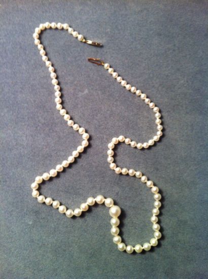 Un collier de perles de culture en chute,...