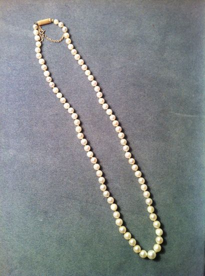 Un collier de perles de culture en chute,...