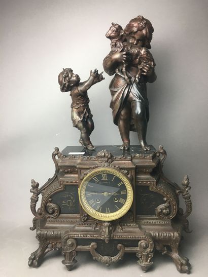Une pendule en régule surmontée d'une plaque...