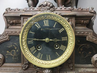 Une pendule en régule surmontée d'une plaque...
