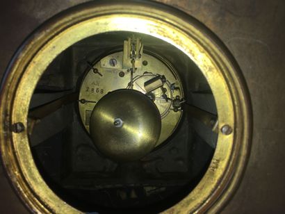Une pendule en régule surmontée d'une plaque...