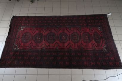 Tapis en laine à décor sur fond rouge d'une...