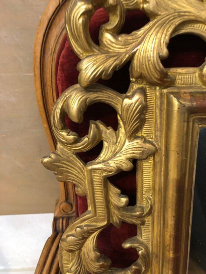 Mirror in a pedimented frame in gilded wood...