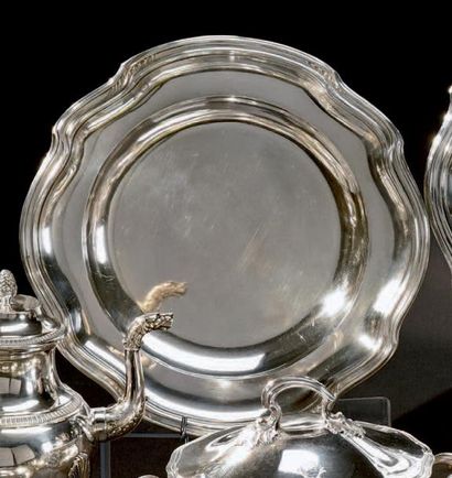 Plat rond en argent, la bordure mouvementée...