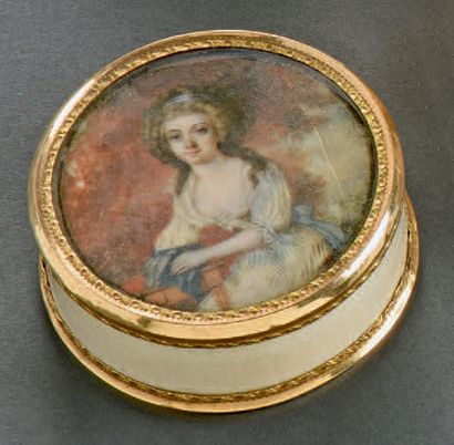 Boîte ronde en ivoire cerclée d'or ciselé,...