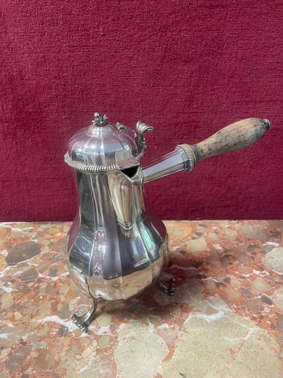 A baluster-shaped silver chocolate pot resting...