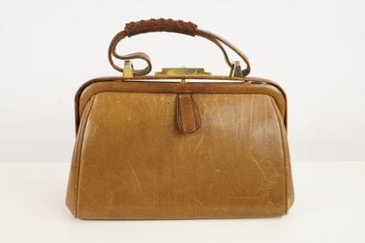 Petit sac à main en cuir brun.
Le cuir est...