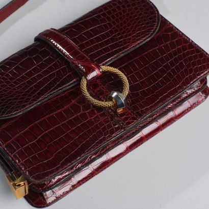 Brown crocodile-style leather handbag.
Twisted...