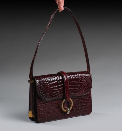 Brown crocodile-style leather handbag.
Twisted...