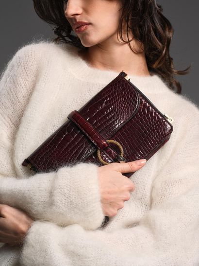 Brown crocodile-style leather handbag.
Twisted...