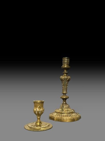 A pair of chiseled bronze candlesticks decorated...