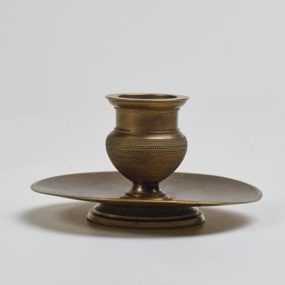 Small bronze torch on a pedestal with a circular...
