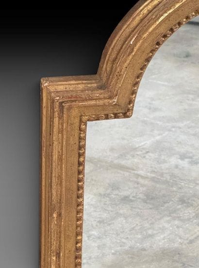 Miroir en bois mouluré, stuqué et doré à...