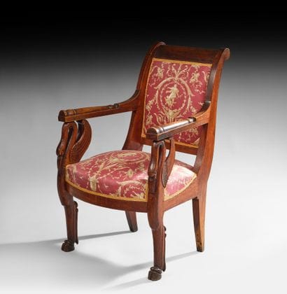 Carved wooden armchair with a curved, crook-shaped...