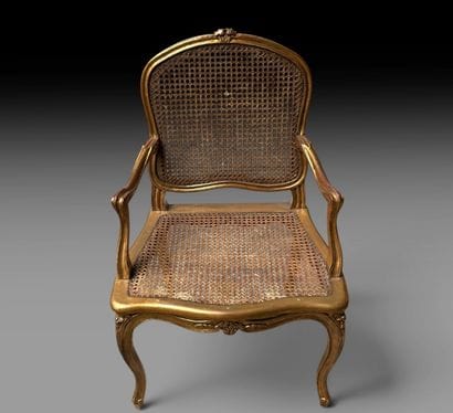 A wooden armchair with molded, carved, and...