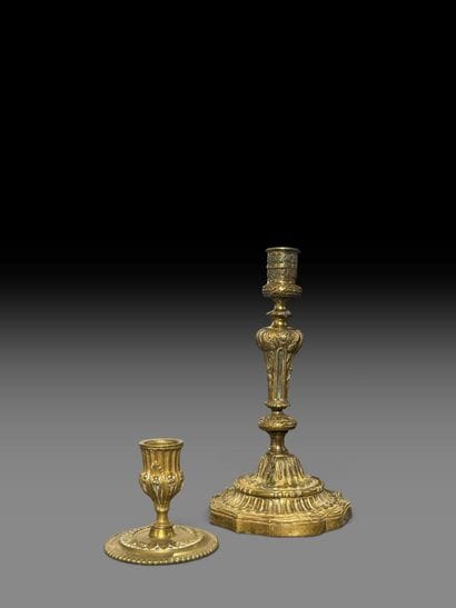 A pair of chiseled bronze candlesticks decorated...
