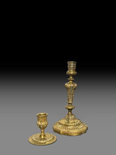 A pair of chiseled bronze candlesticks decorated...