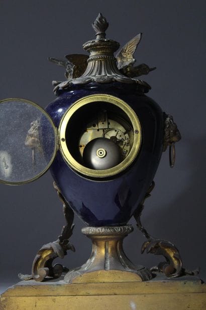 Bronze and metal clock with a case shaped...