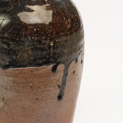 A terracotta bottle glazed brown to black...