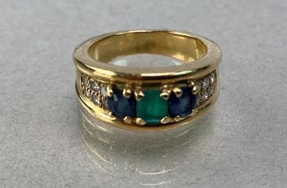 Yellow gold band ring set with a green stone...