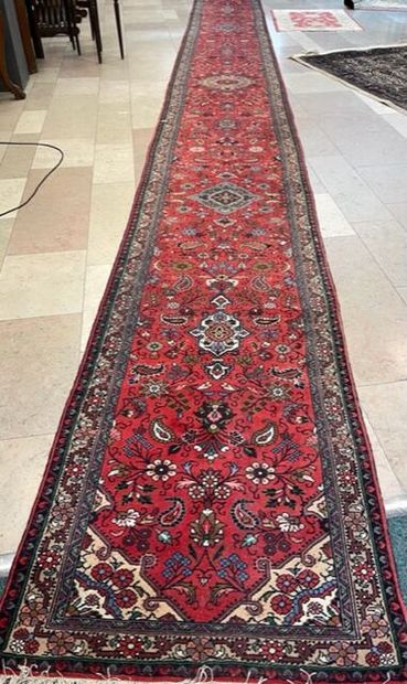 Tapis galerie en laine sur fond rouge à décor...