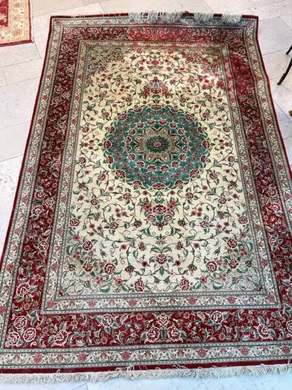 Tapis en laine et soie sur fond beige à bordures...