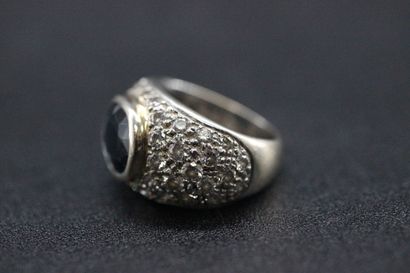 White gold dome ring set with a dark sapphire...