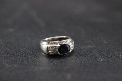 White gold ring set with a blue stone in...