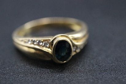 Yellow gold ring with a blue stone and small...