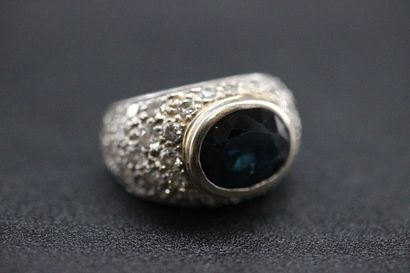 White gold dome ring set with a dark sapphire...