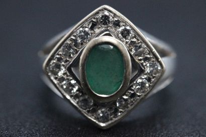 White gold ring set with a green stone in...
