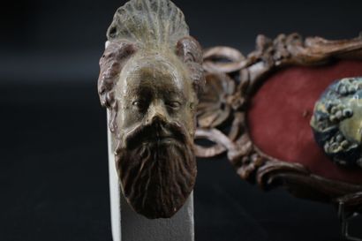 2 terracotta mascarons, one stylizing Bacchus...