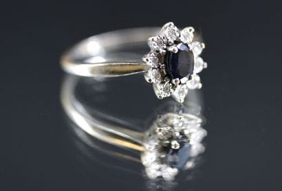 Daisy ring in 18k white gold set with a blue...