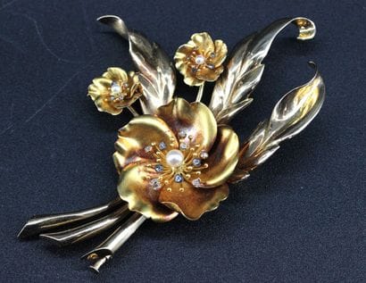 Broche en or jaune 18k stylisant des fleurs...