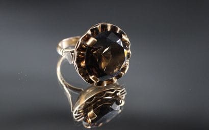 14K yellow gold ring set with a large dark...
