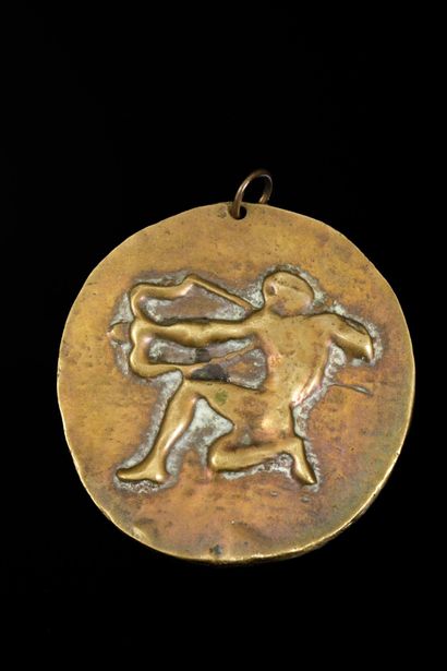 Pendentif en métal doré figurant à l'avers...