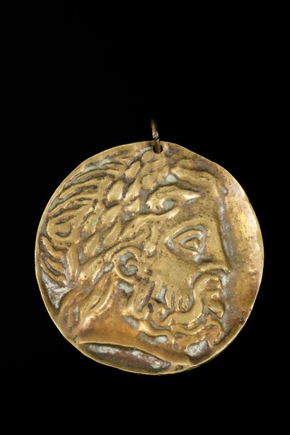 Pendentif en métal doré figurant à l'avers...