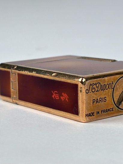 Dupont 
Briquet en laque brune et métal dorée...