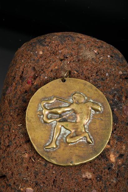 Pendentif en métal doré figurant à l'avers...
