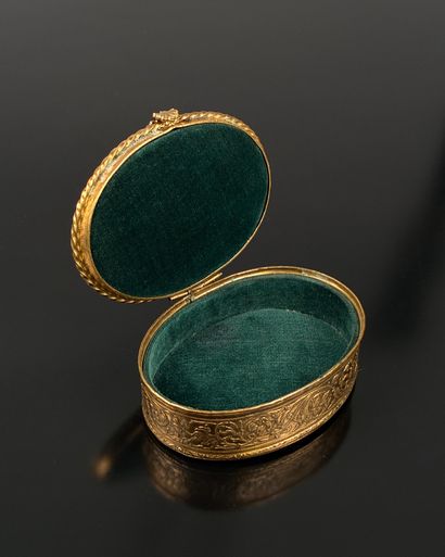 A small, oval-shaped jewelry box made of...