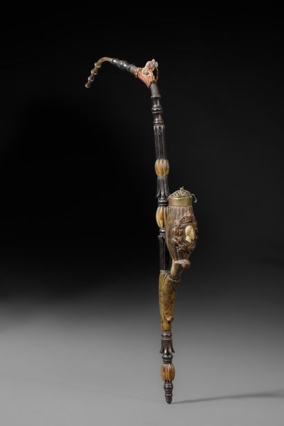 A large wooden and horn pipe with a bowl...