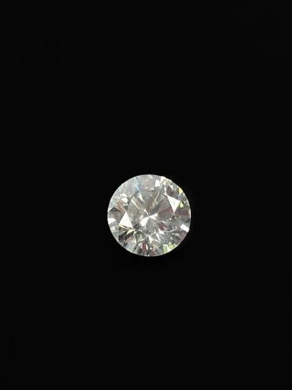 Round brilliant-cut diamond on paper weighing...
