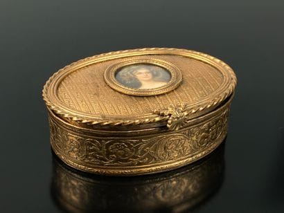 A small, oval-shaped jewelry box made of...