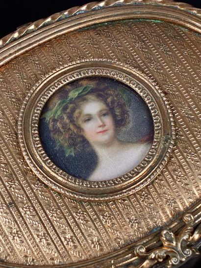 A small, oval-shaped jewelry box made of...