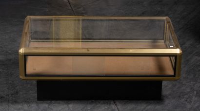 Table basse vitrine en laiton et verre. 40...